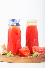 Homemade Tomato sauce, ketchup in glass bottles and ingredients on a white background