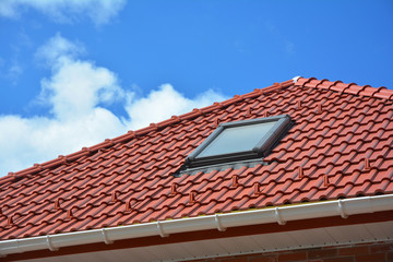 Attic skylight. Roof Tiles House Roofing Construction with Attic Roof windows, skylight waterproofing.