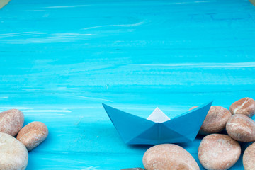 Sand, seashells, stones, ship on a blue background. Concept of rest. Top view.