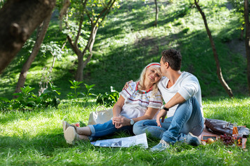 Free time. Pleased mature woman keeping smile on her face while leaning on shoulder of her son