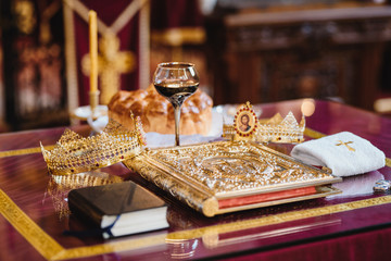 Fototapeta na wymiar Objects for a orthodox wedding ceremony - a glass of wine, bread and religious book.