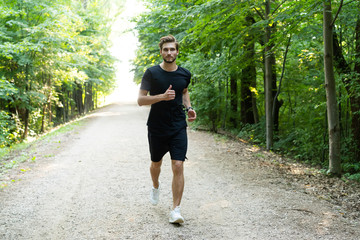 Athletic young man running in the nature. Healthy lifestyle