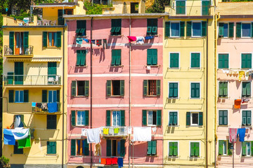 Fototapeta na wymiar View on the beautiful colourful houses with clothes drying in the sunny daylight in Cique Terre, Italy.