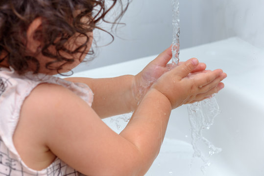 Child washing hand with water.Prevent Flu: To keep the flu virus at bay, wash your hands with soap and water several times a day.