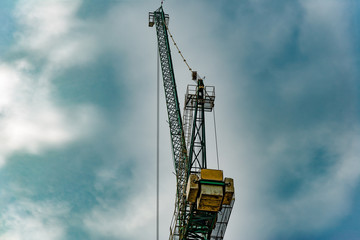 Fototapeta na wymiar HDR photo of a tower crane on the construction site of a high-rise building. The concept of the construction business.