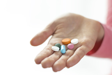 Different pills and capsules in the woman's hand. Tablets close-up.