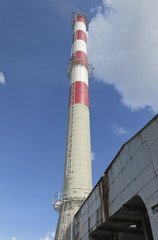 A high red-white concrete industrial chimney
