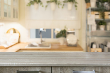 Blurred background. Modern defocused pastel kitchen with wooden tabletop and space for you.