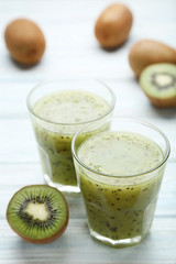 Fresh kiwi smoothie in glass on wooden table