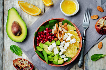 Pomegranate avocado spinach orange feta salad in a bowl