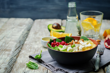 Pomegranate avocado spinach orange feta salad in a bowl