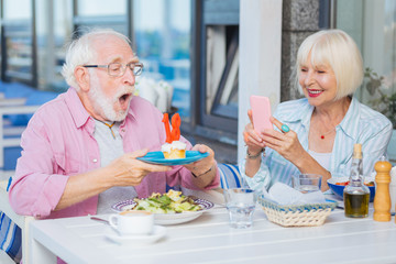 My wish. Joyful elderly man blowing at the candles while making a wish