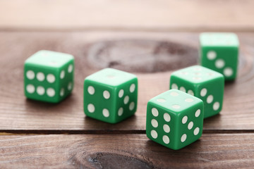 Green dice on brown wooden table