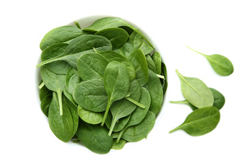 Spinach leafs in bowl isolated on white background