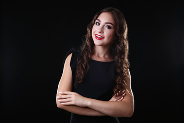 Young woman in modern dress on black background