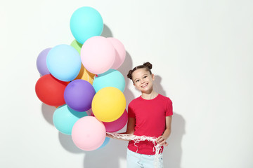 Fototapeta na wymiar Beautiful young girl with colored balloons on white background
