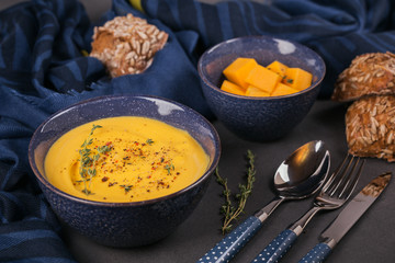 Pumpkin soup in blue bowl topped with fresh herb