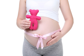 Pregnant woman with pink ribbon and toy on white background