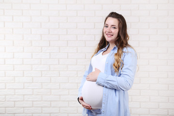 Beautiful pregnant woman on brick wall background