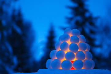 Snowball lantern in winter landscape at dusk.