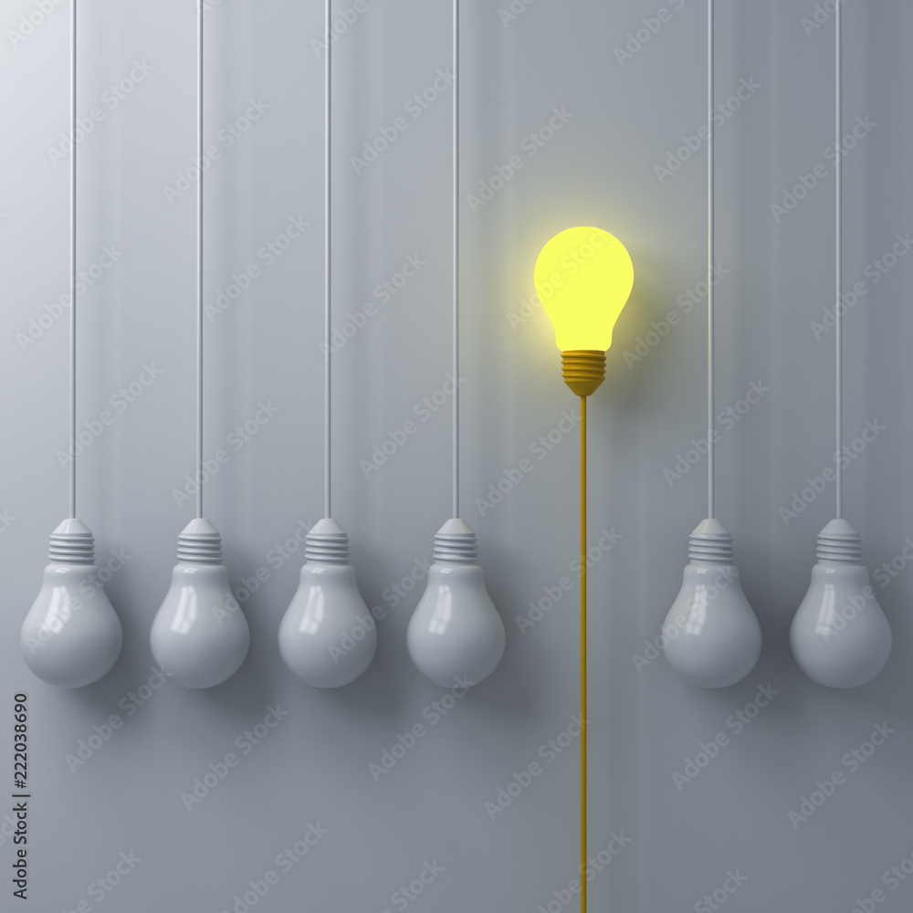 Poster think different concept one glowing light bulb standing out from the dim or unlit white lightbulbs o