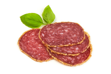 Smoked salami sausages slices with basil leaves, isolated on white background