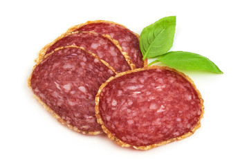 Smoked salami sausages slices with basil leaves, isolated on white background