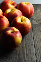Group of ripe nectarines on dark wooden surface
