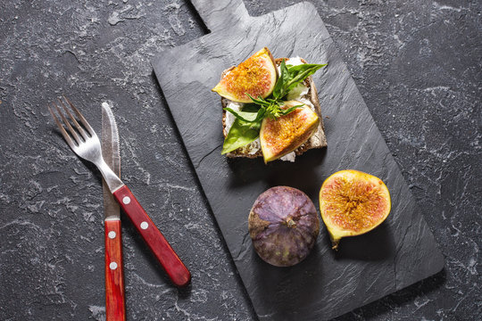 Figs fruit sandwich on a slate plate on a black background