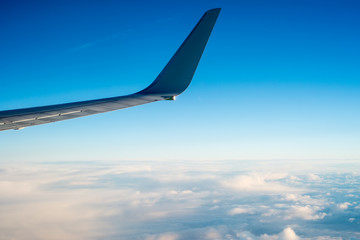 Naklejka na ściany i meble Wing of the plane on blue sky background