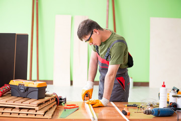 Young man carpenter working in workshop 