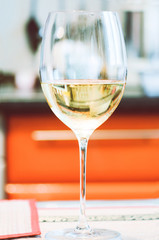 A glass of champagne is on the table, close-up, soft focus.