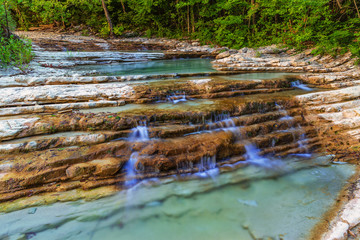 Water stream in mountain of Caucasus. The beautiful summer landscape with water and water stream on forest of Caucasus mountain.