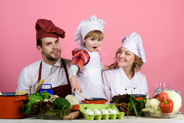Cooking, healthy eating, child, happy family. Father&mother with toddler boy cooking at kitchen. Happy family preparing vegetables together at home in kitchen. Parents with little son cooking together