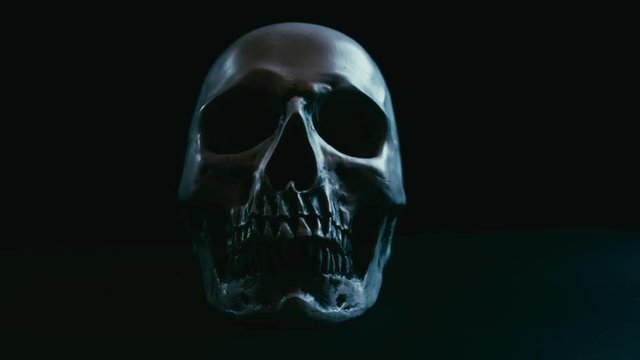 Skull in darkness,vertical stabilizer camera sudden movement with spot lights on and off