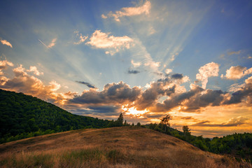 Naklejka na ściany i meble Beautiful sunset view with sunrays bursting from the clouds
