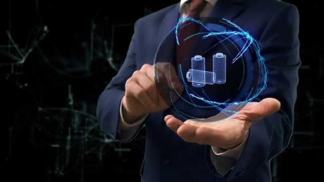 Businessman shows concept hologram 3d Batteries on his hand. Man in business suit with future technology screen and modern cosmic background
