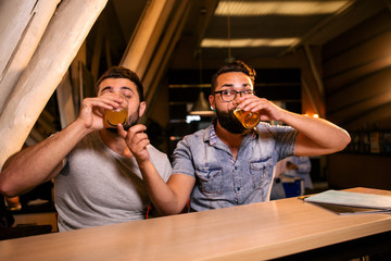 Two brutal men drinking beer in a cafe sitting at the table