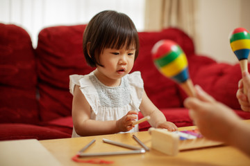 baby girl play maracas at home