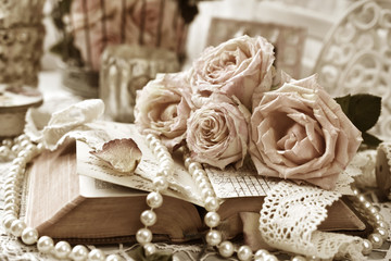 vintage style still life with roses and old book in sepia
