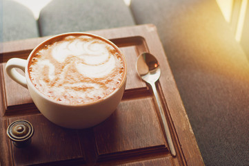 Top view of hot coffee cappuccino latte art in white ceramic cup on wooden plate. Coffee cup top view on old wooden. Coffee cup in coffee shop