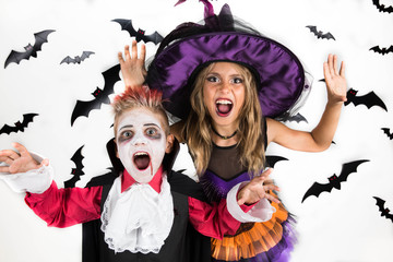 Halloween kids, Happy scary girl and boy dressed up in halloween costumes of witch, sorcerer and vampire, Dracula for pumpkin patch and halloween party