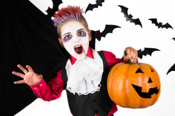 Halloween kids. Spooky Boy with a halloween costume of a vampire Dracula with halloween pumpkin jack o lantern, ready for halloween party or pumpkin patch