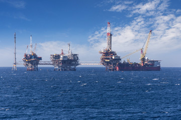 Obraz premium Big offshore oil rig drilling platform complex with anchored ship