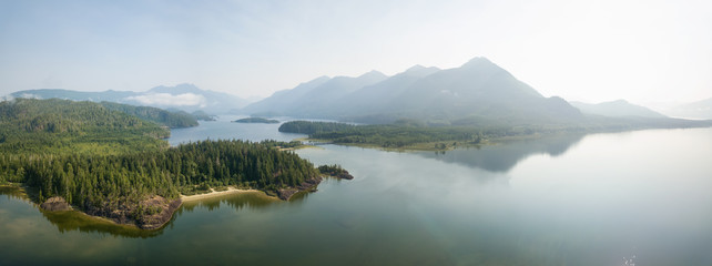 Naklejka premium Aerial panoramic landscape view of Kennedy Lake during a cloudy summer day. Taken near Tofino and Ucluelet, Vancouver Island, BC, Canada.