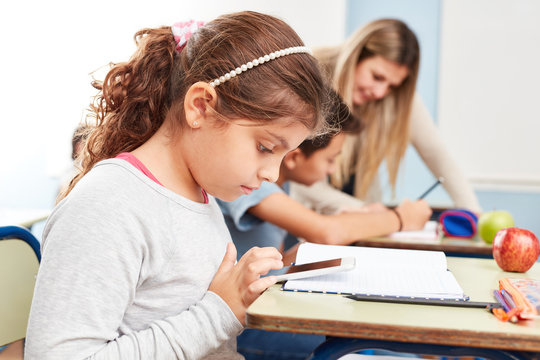 Schülerin beim Chatten im Unterricht - Powered by Adobe