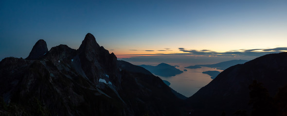 Beautiful panoramic view of The Lions Peaks and Howe Sound during a vibrant summer sunset. Located near Vancouver, BC, Canada.