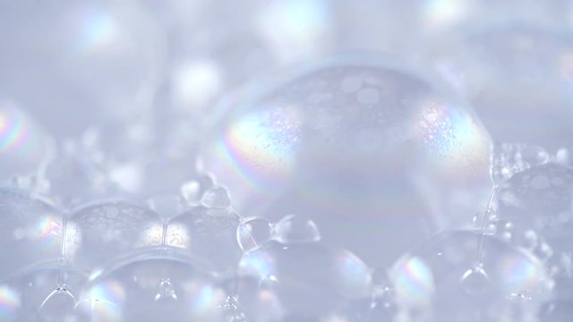 Foam. Soap foam popping bubbles background. Foam macro structure closeup. Washing concept. Rotation 4K UHD video 3840X2160