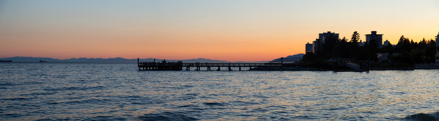 Obraz premium Beautiful panoramic view of the wooden quay at Ambleside Park during a vibrant summer sunset. Taken in West Vancouver, BC, Canada.
