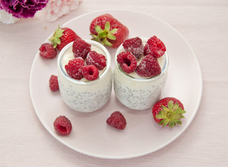 fresh natural yoghurt with sage seeds decorated with strawberries and frozen raspberries